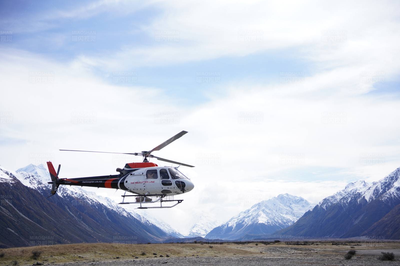 直升机在雪山间飞行图片