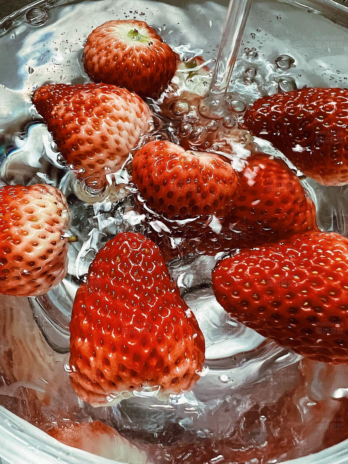 新鲜草莓在水中清洗图片