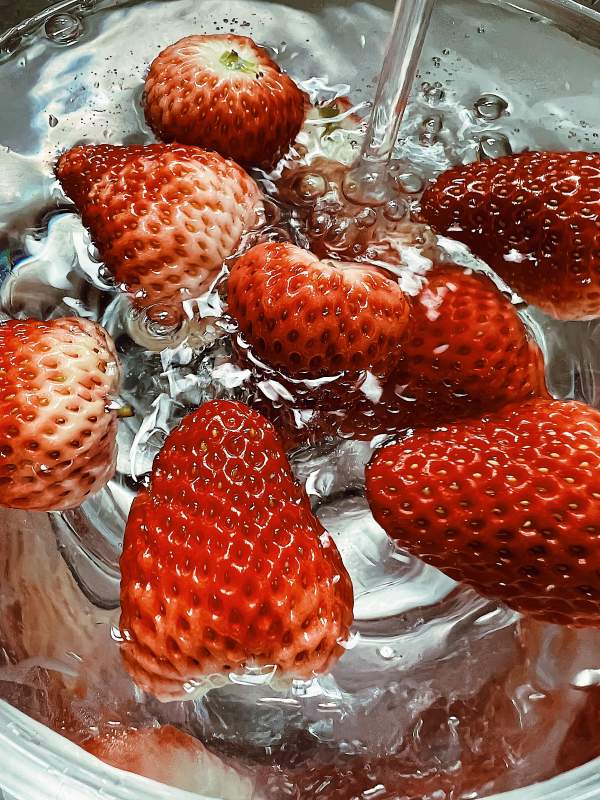 新鲜草莓在水中清洗图片