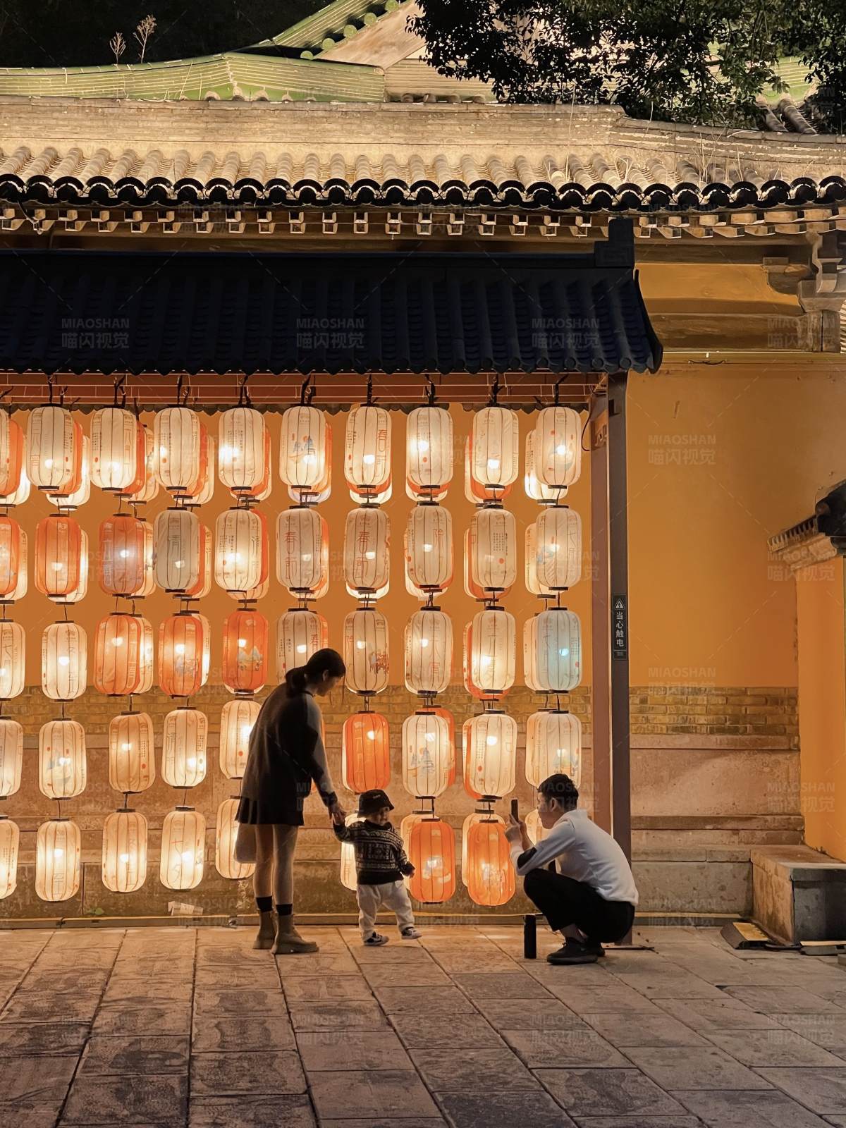 夜幕下的灯笼墙与家庭时光图片