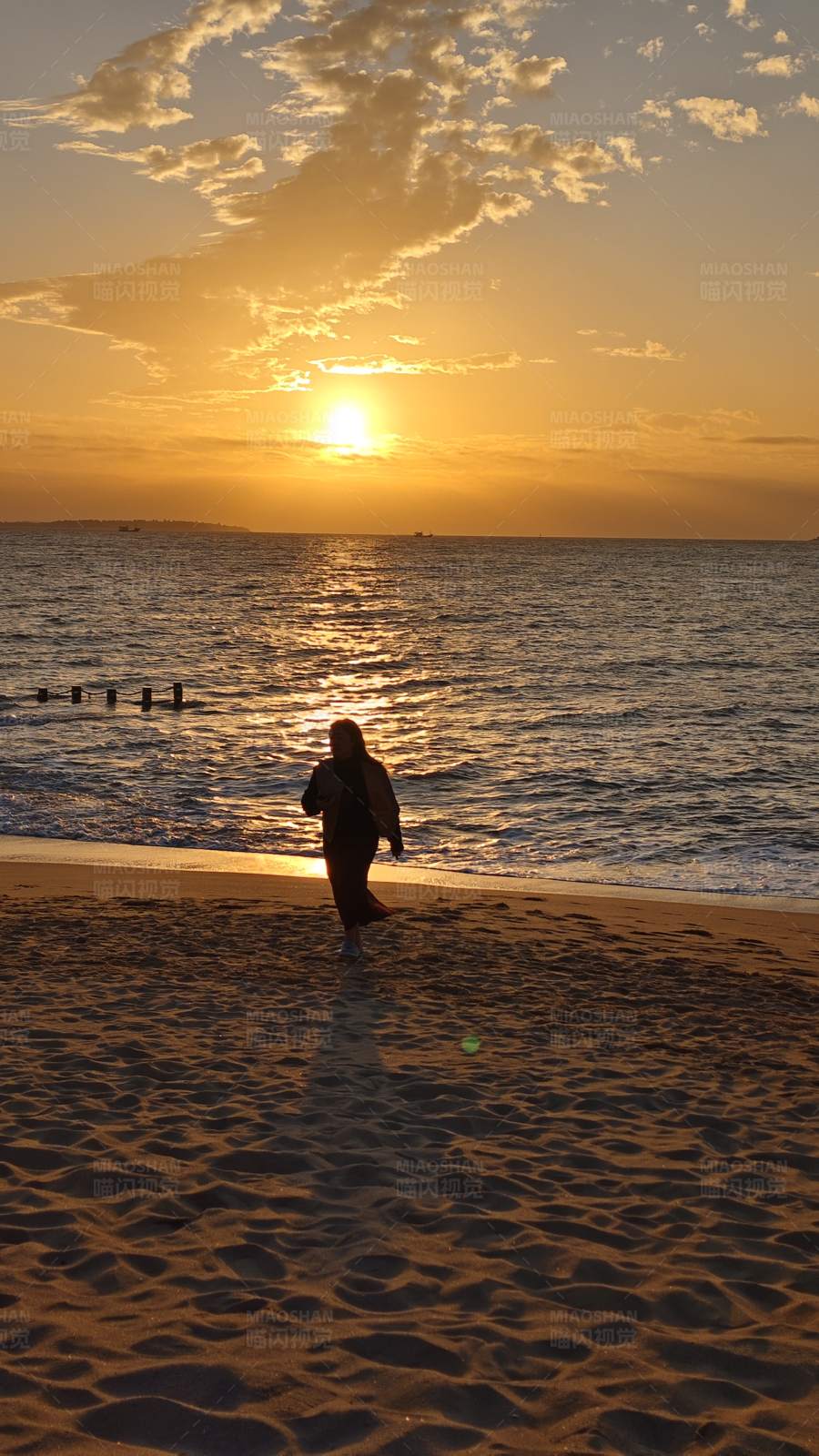 夕阳下的海滩漫步图片