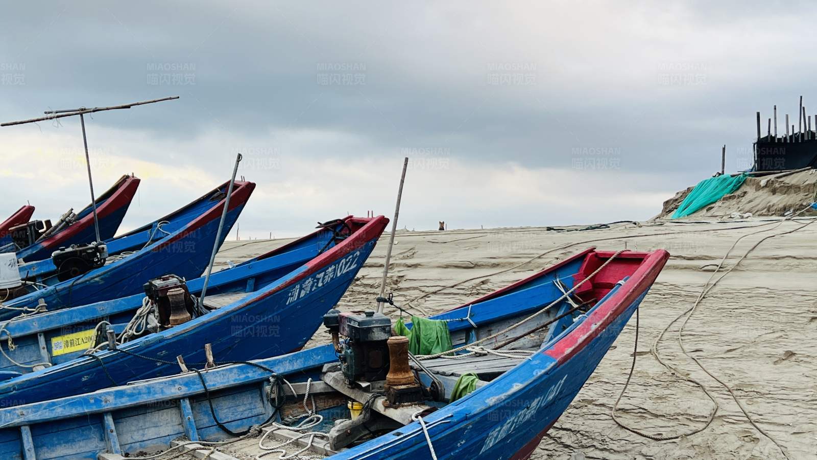 海滩上的蓝色渔船图片
