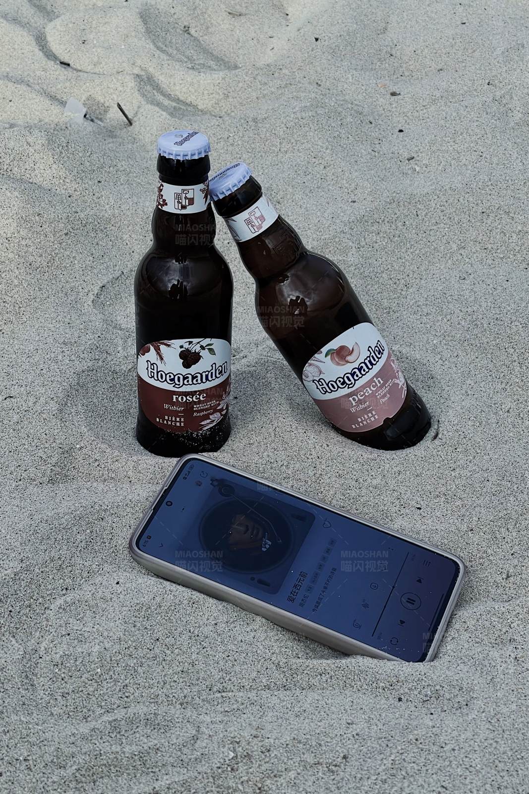 沙滩上的啤酒和手机图片