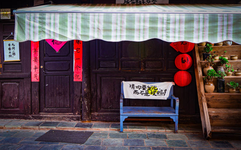 古街店铺前的蓝色长椅图片
