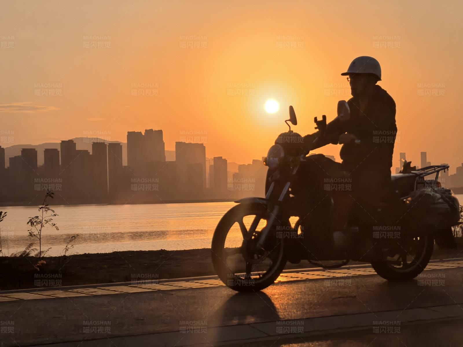 夕阳下的摩托车骑士图片