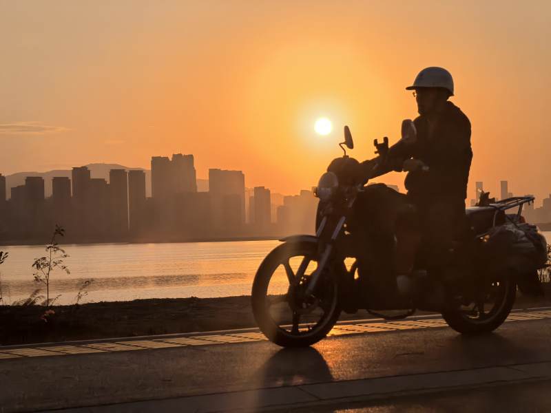 夕阳下的摩托车骑士图片