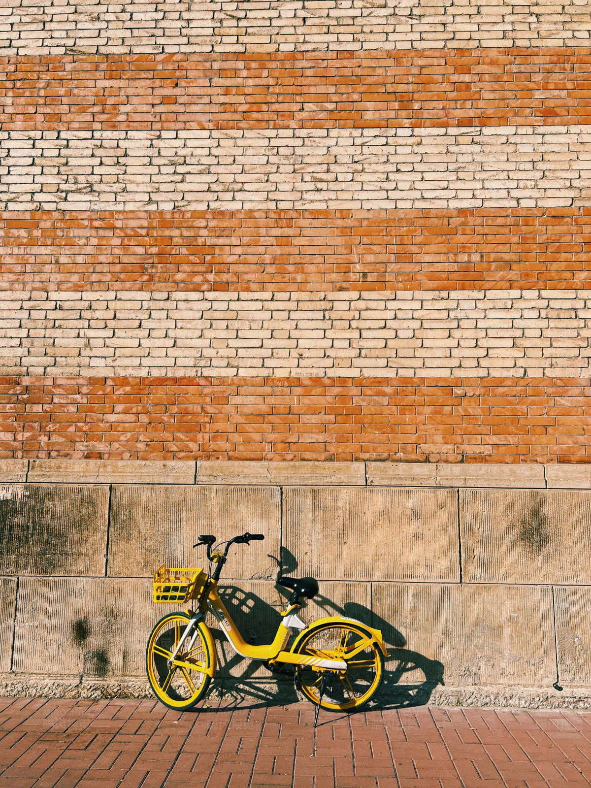黄色单车靠砖墙图片