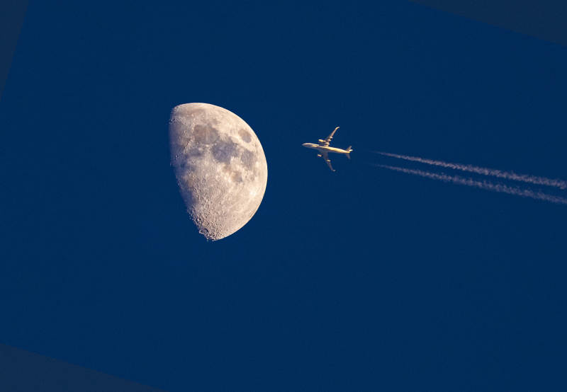 飞机掠过半轮明月图片