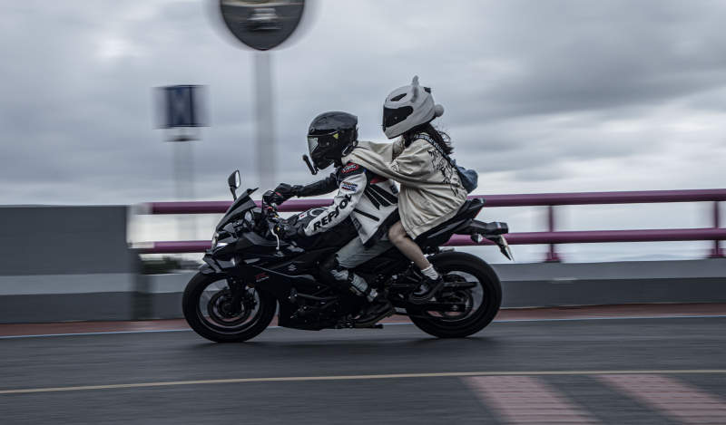 雨中疾驰的摩托车双人行图片