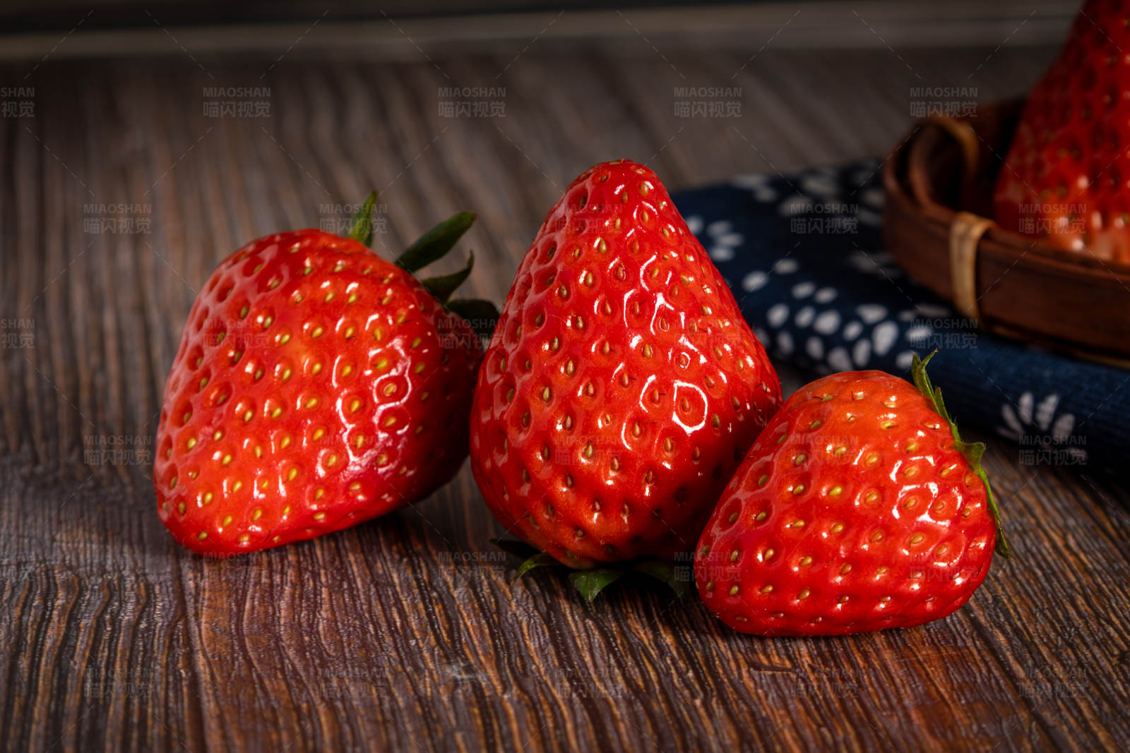 木桌上三颗草莓图片