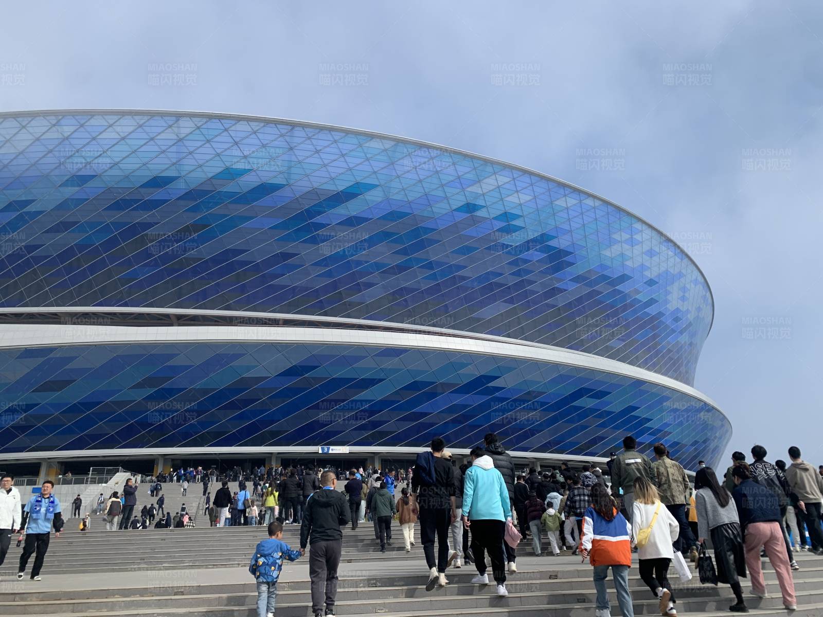 蓝色体育场前的人群图片