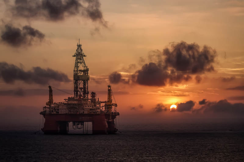 日出时的海上钻井平台图片