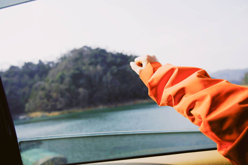 车窗伸出手 湖景山色图片