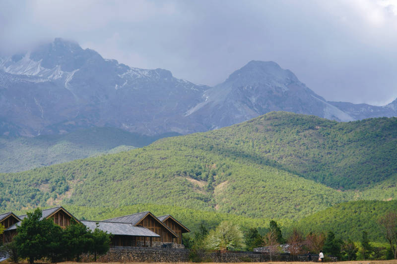 雪山脚下的宁静村庄图片
