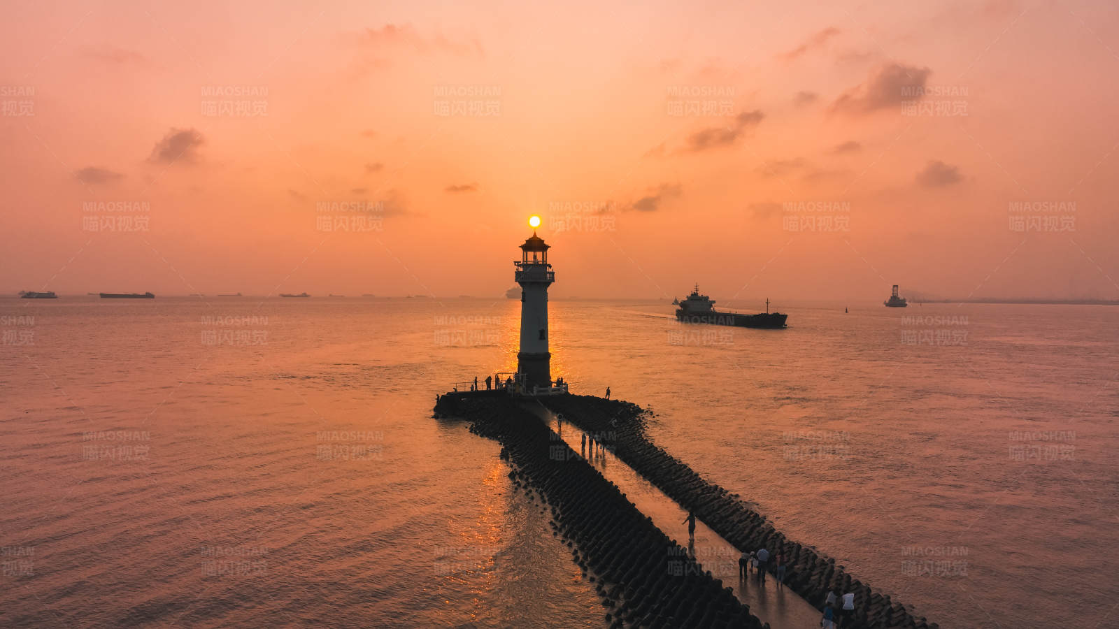日落灯塔海上剪影图片