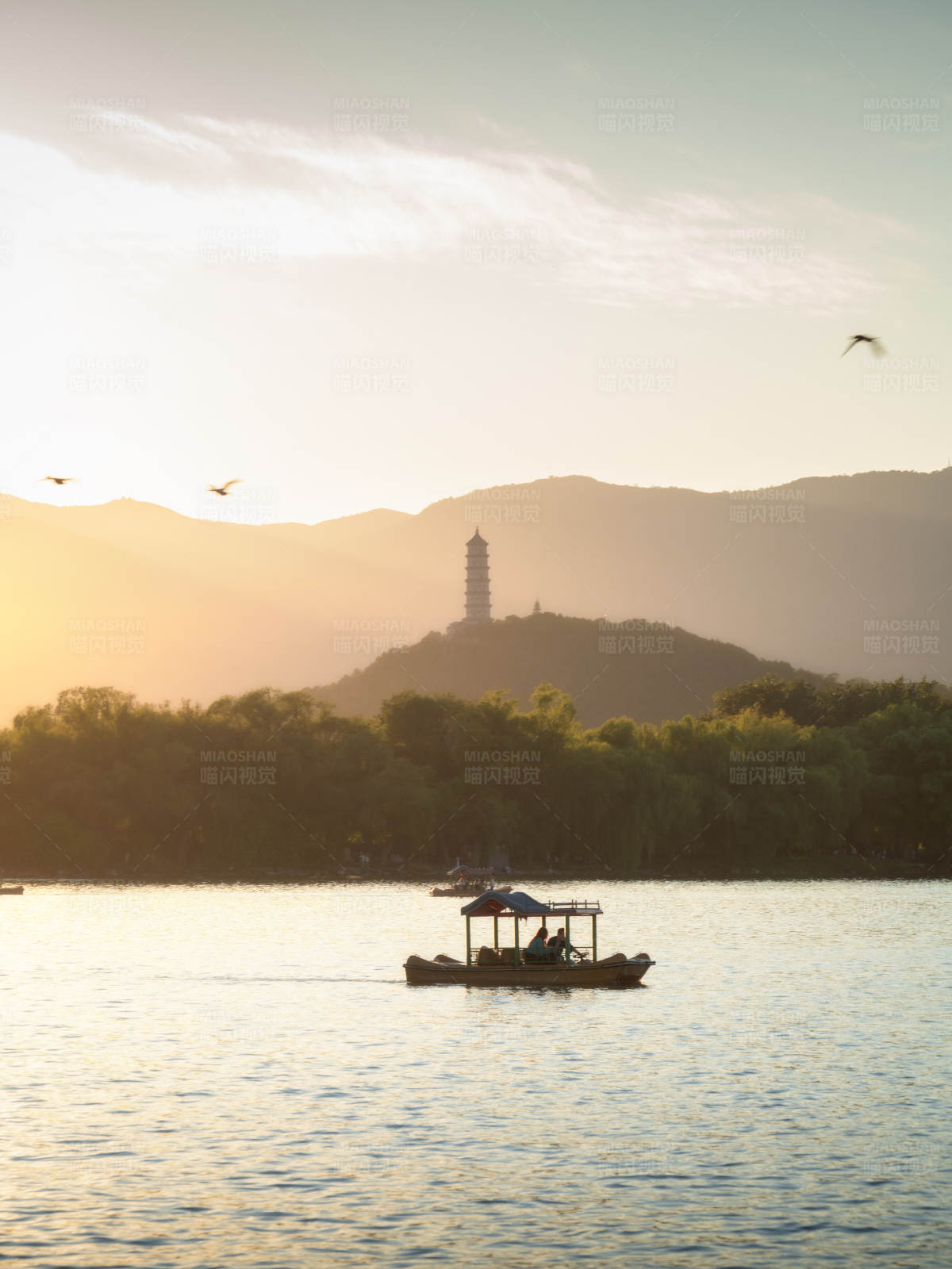 夕阳下颐和园昆明湖中的游船图片