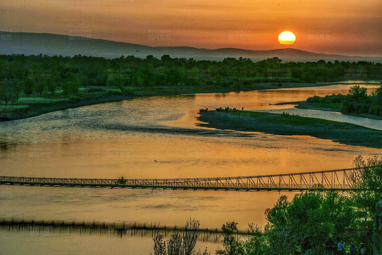 夕阳下的河上悬索桥图片