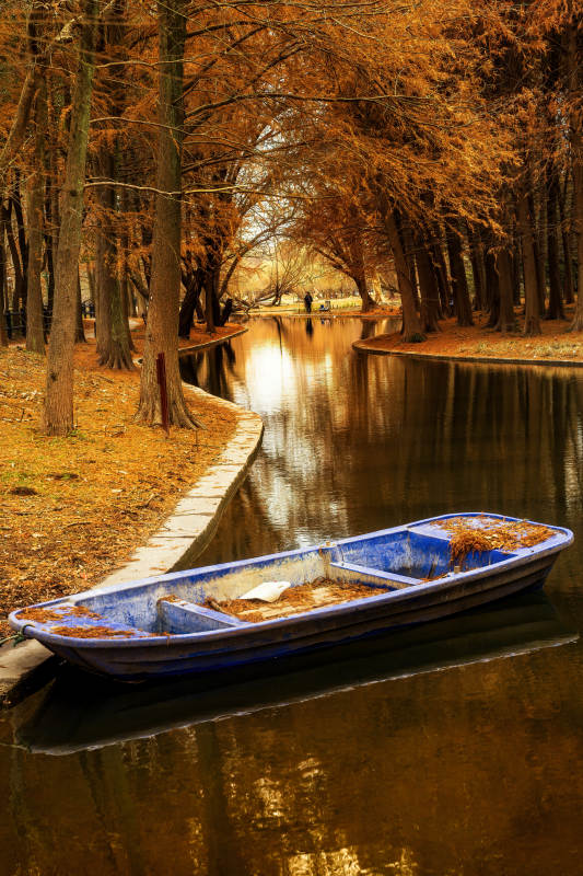 秋日小河上的蓝色小船图片