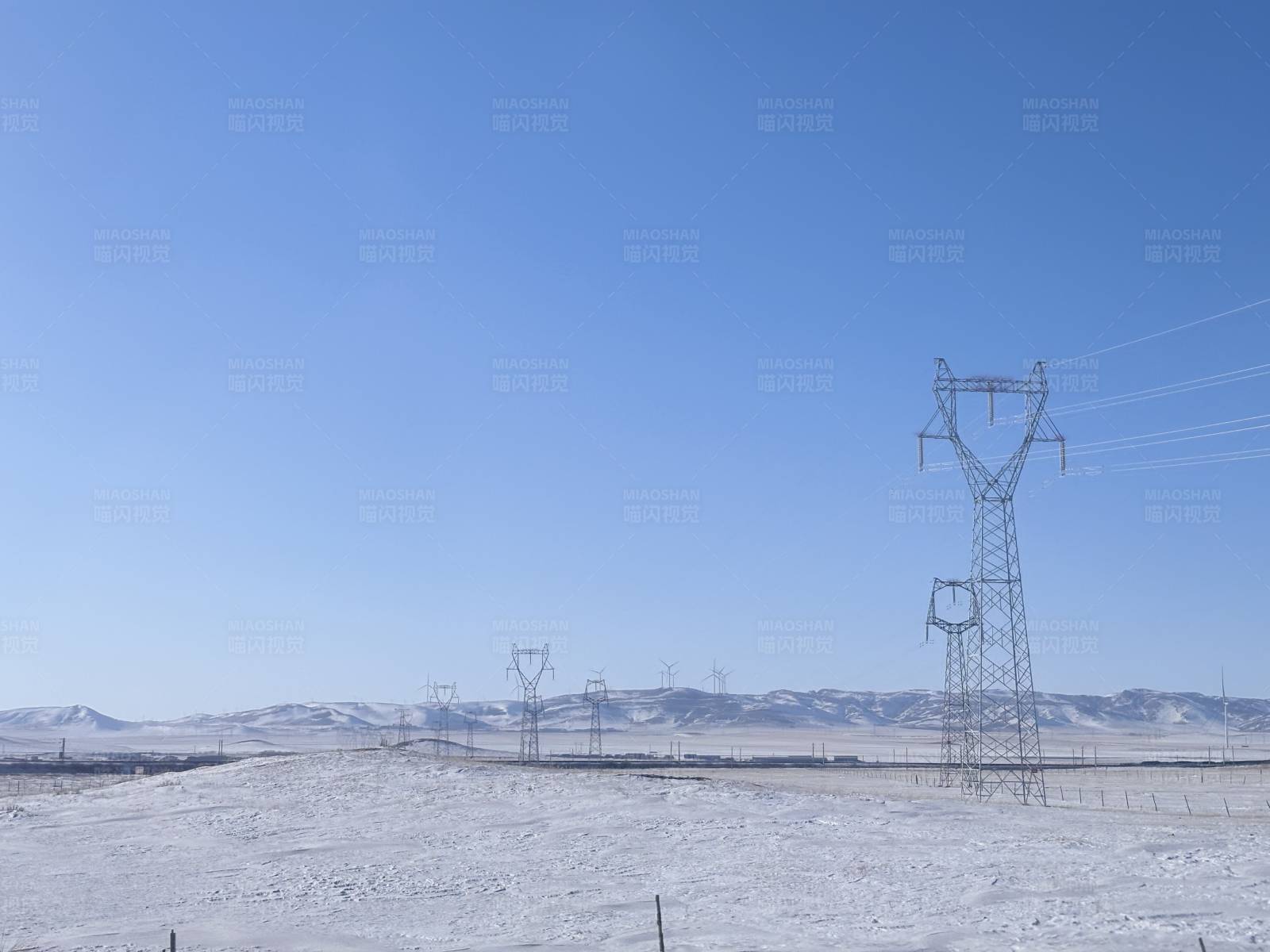 雪原上的输电铁塔图片
