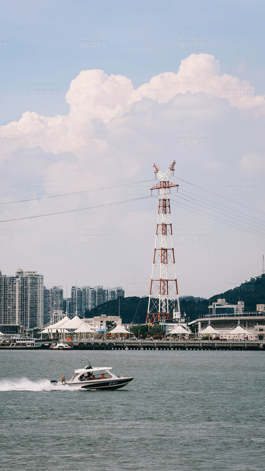 城市湖畔的快艇与塔架图片