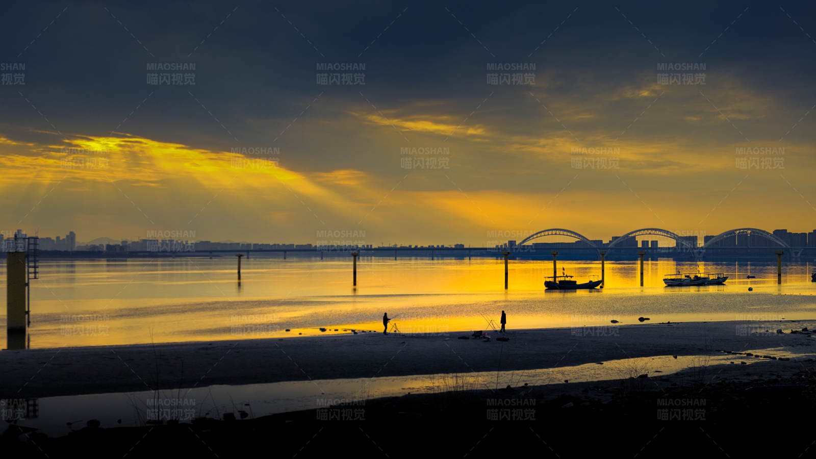 夕阳下的海滩与桥梁图片