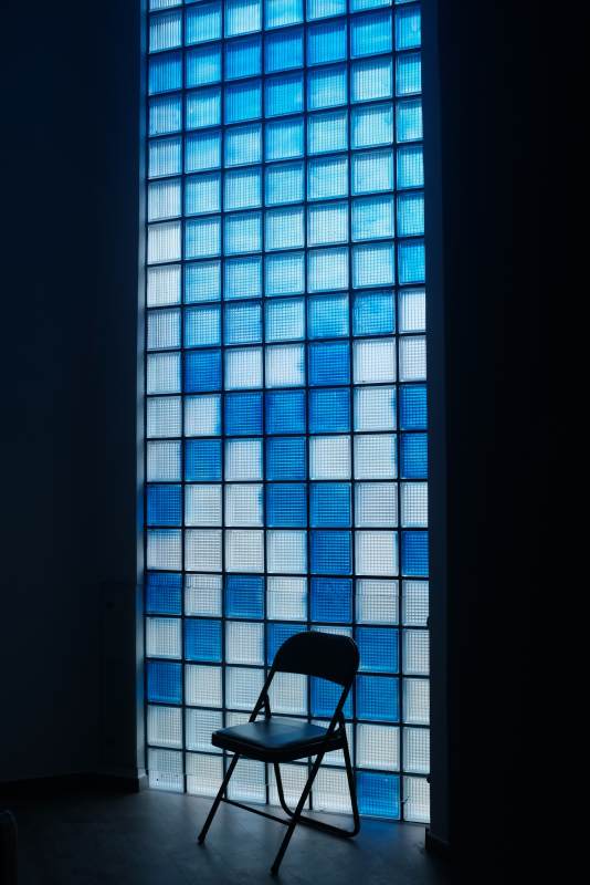 蓝白格窗前的孤独椅图片