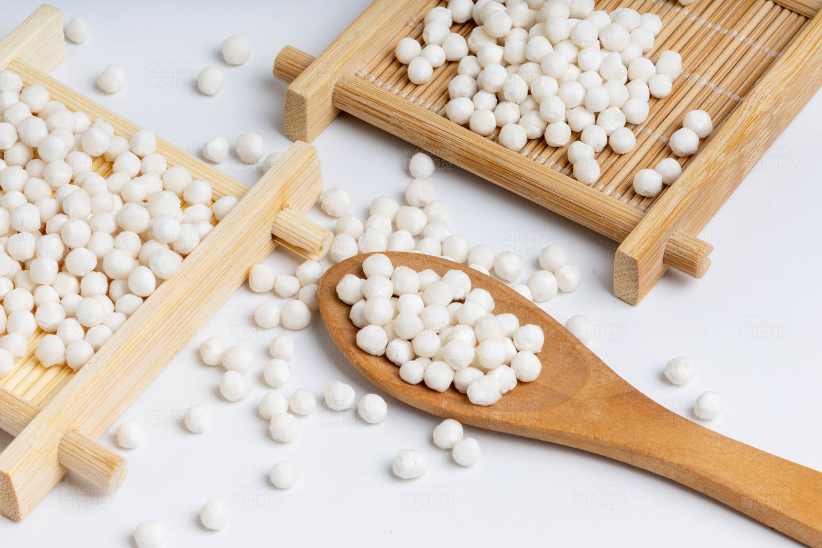 木勺与竹盘上的西米谷物图片