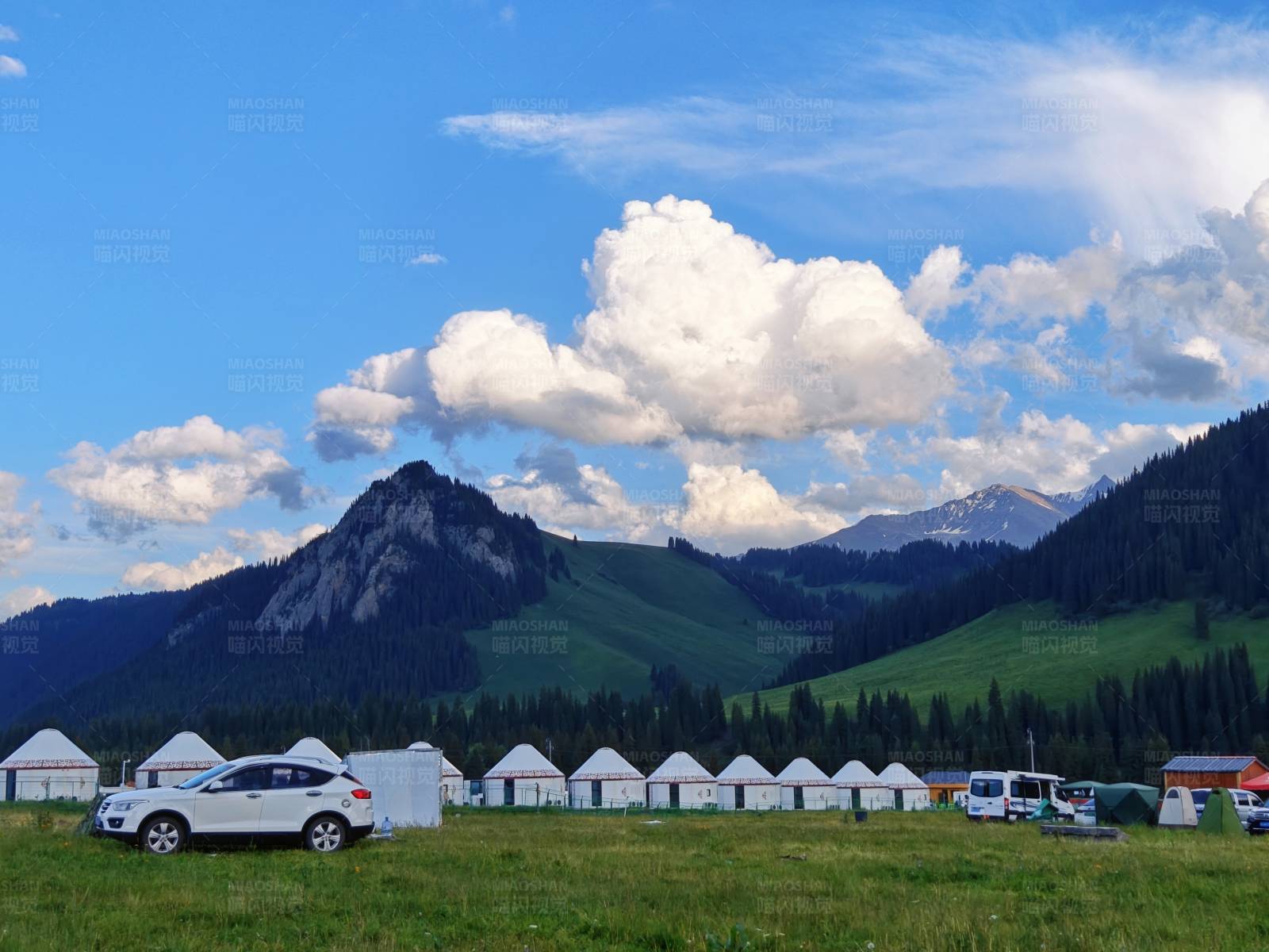 百里画廊草原上的白色帐篷营地图片