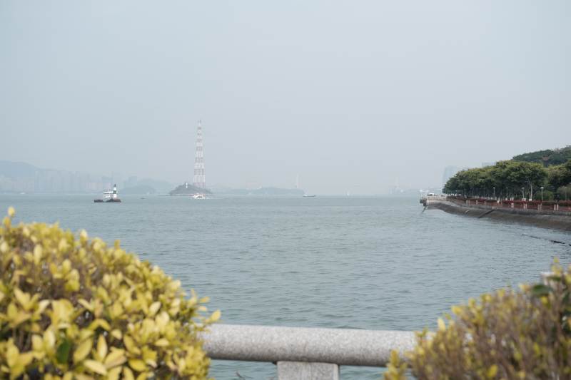 江边风景与远处灯塔图片