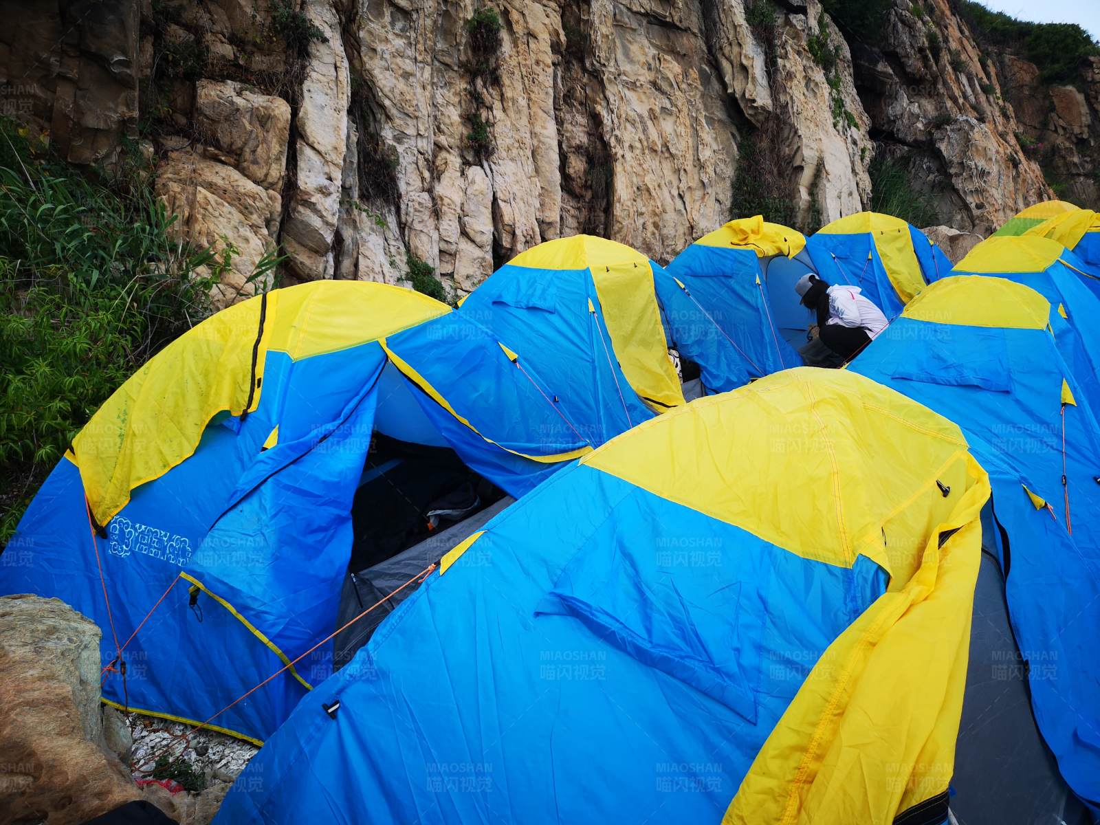 悬崖边的蓝色帐篷群图片