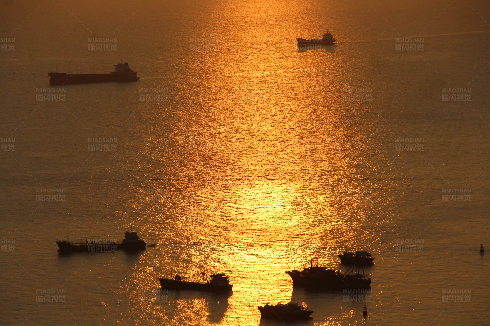 夕阳下的海上船影图片
