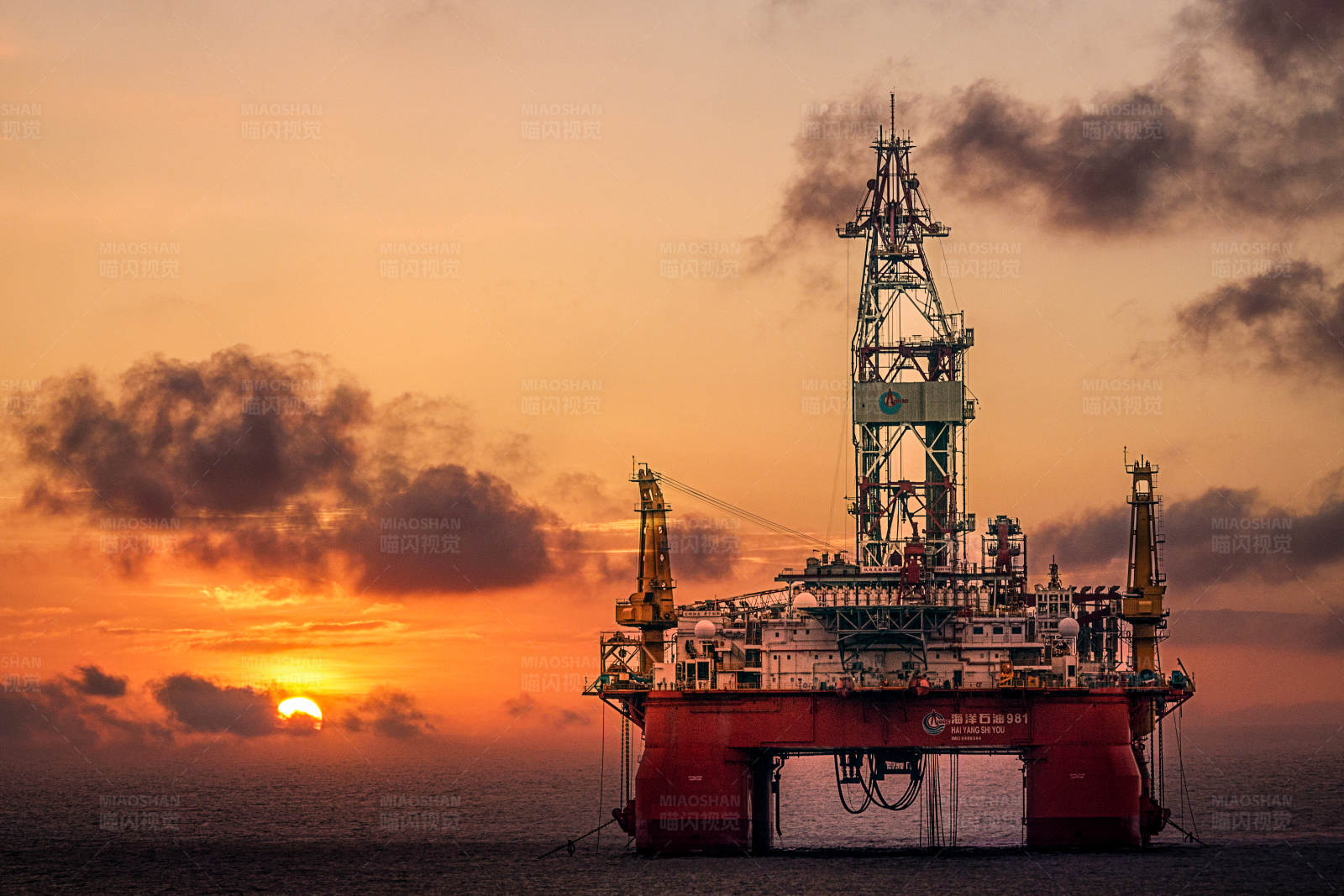 夕阳下的海上钻井平台图片