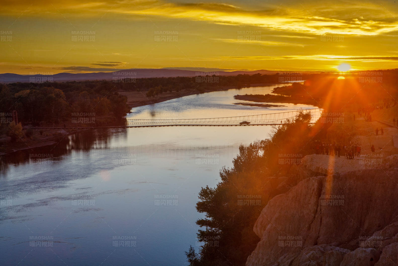夕阳下的河上悬索桥(布尔津)图片