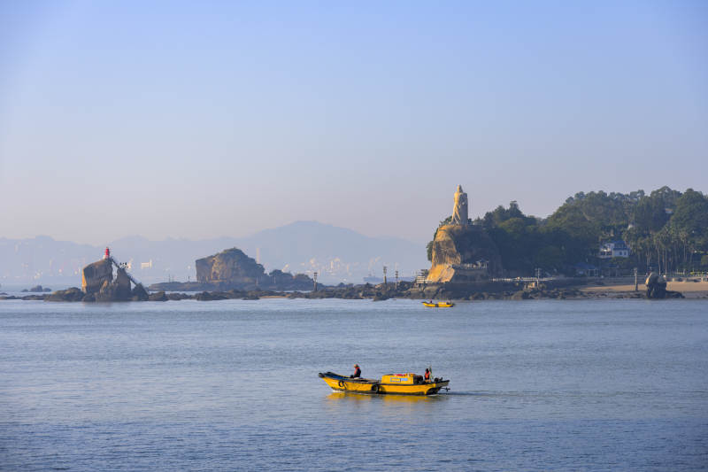 海上渔船与远处灯塔图片