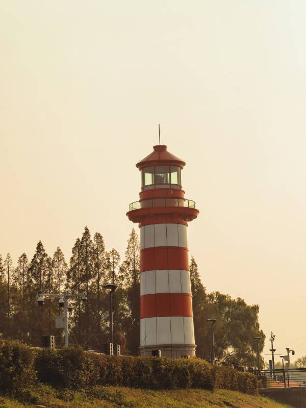 夕阳下的红白灯塔图片