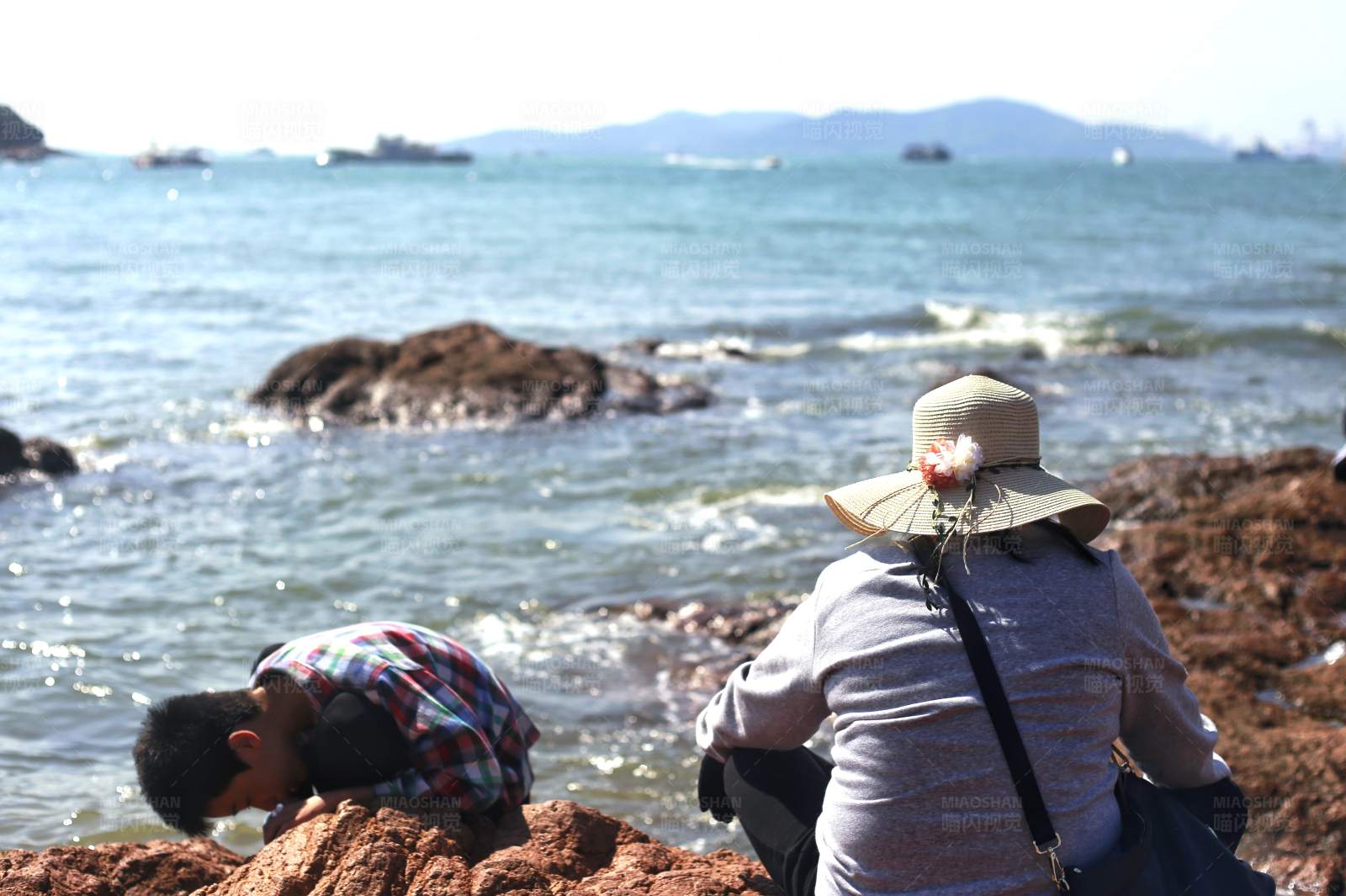 海边拾贝的两人图片