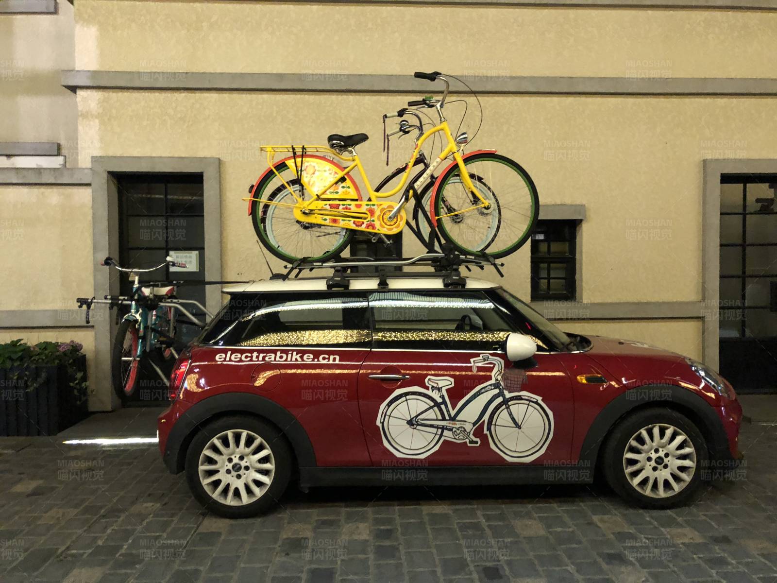 红色小车上的黄色自行车图片