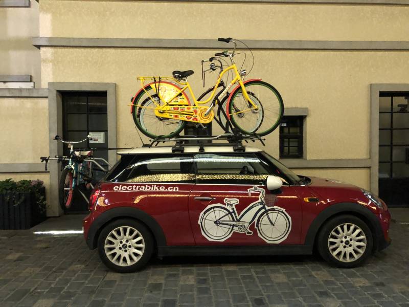 红色小车上的黄色自行车图片