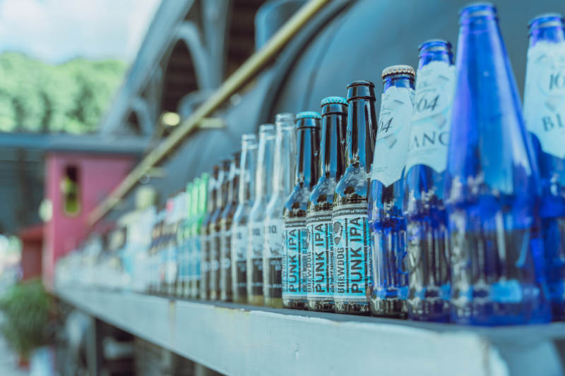 啤酒瓶排列在栏杆上图片