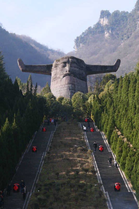 巨石雕像与登山游客图片