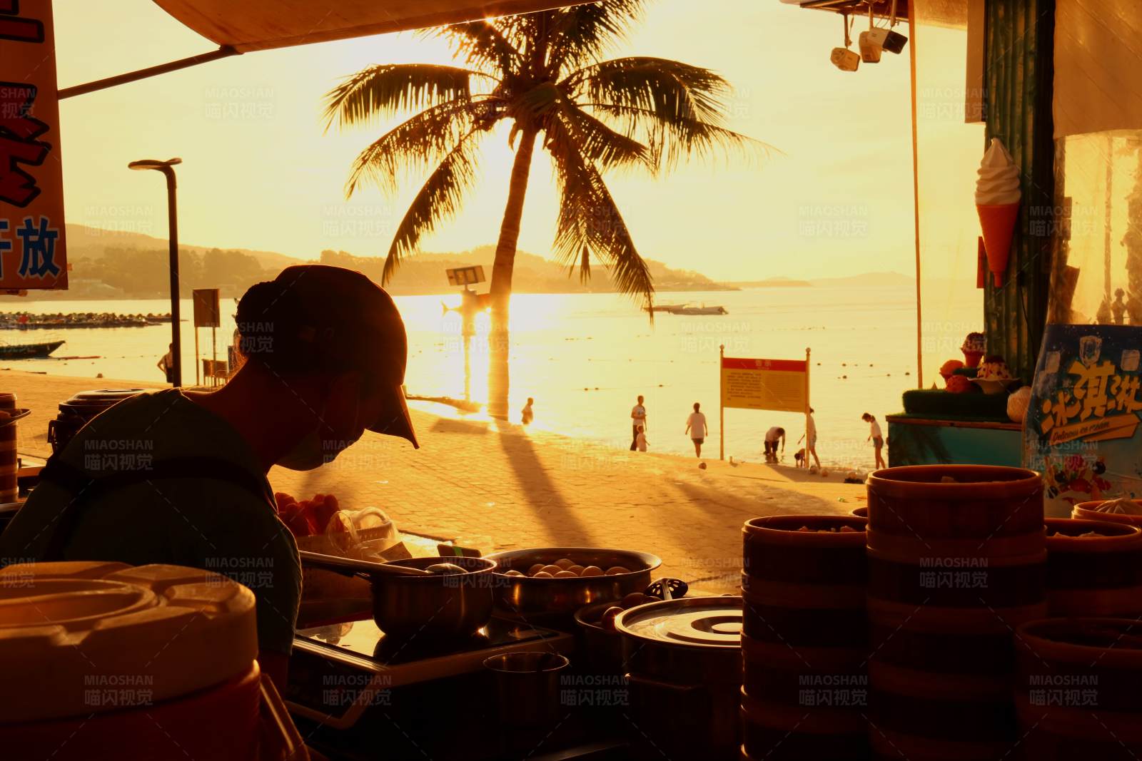 夕阳下的海滩小吃摊图片