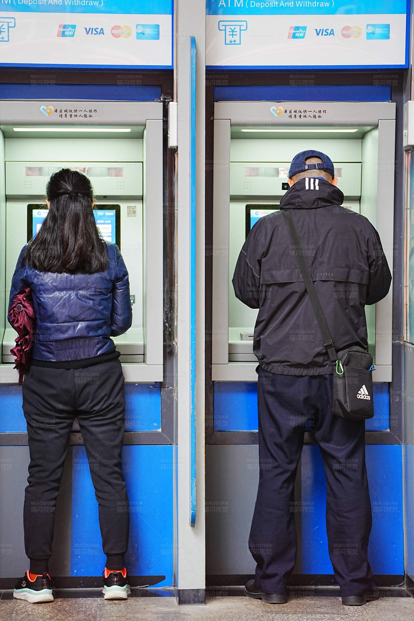 两人使用ATM机图片