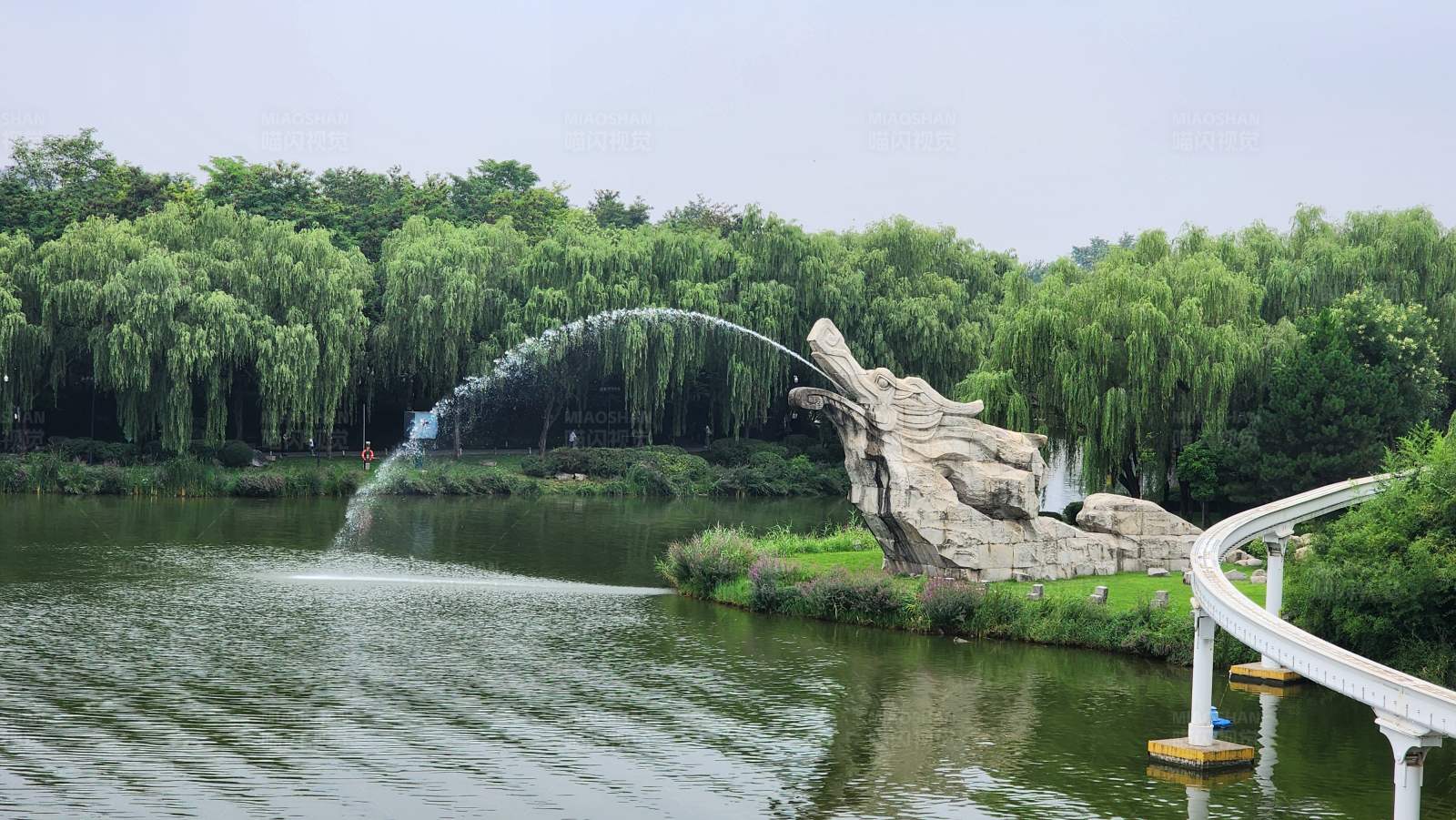 湖畔喷泉与石雕图片