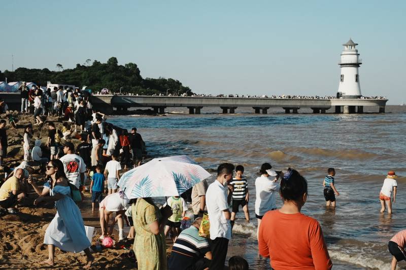 海滩灯塔游人如织图片