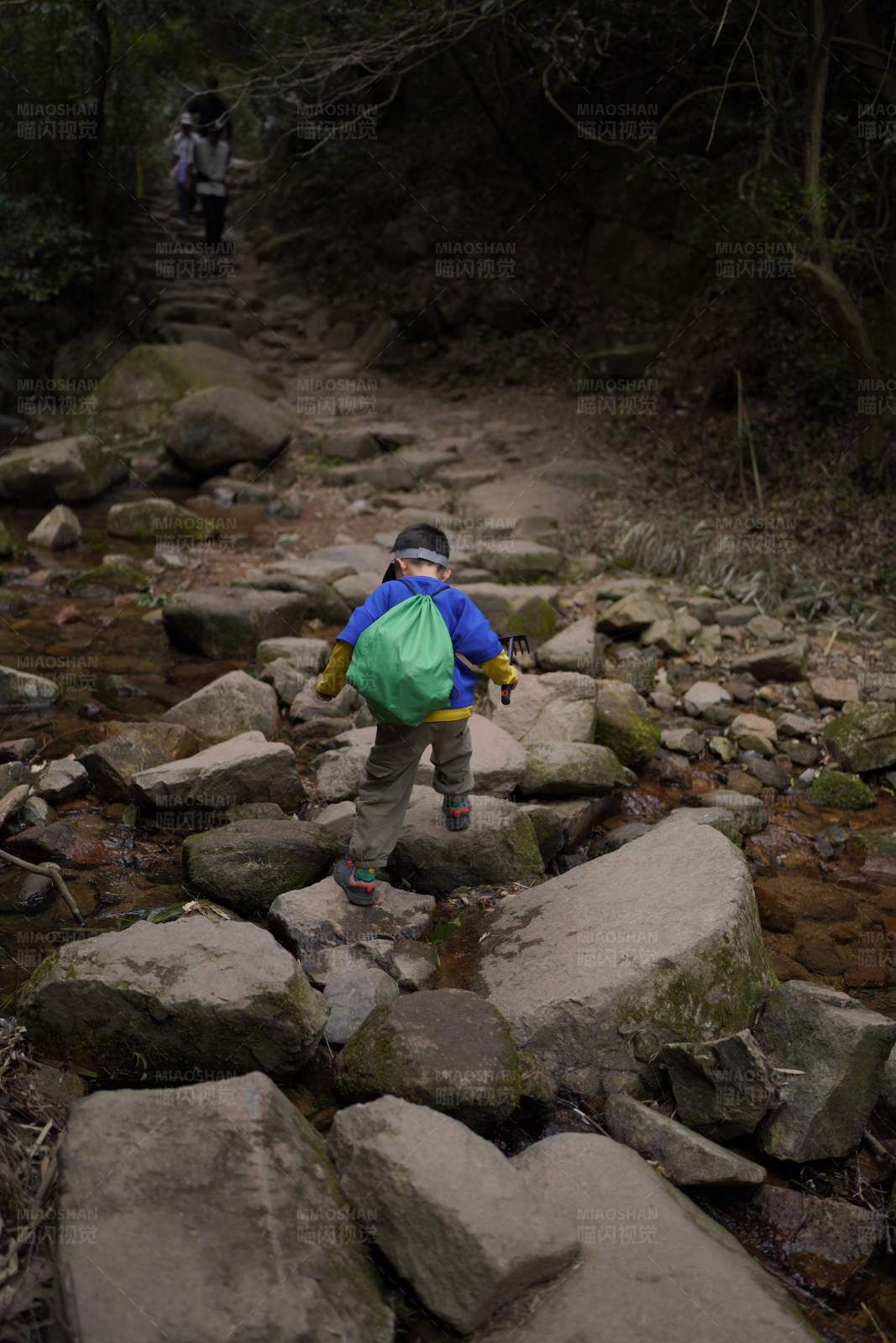 小童徒步山间溪流旁图片