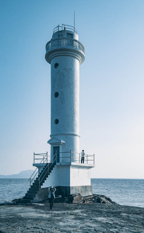 海边灯塔与游客图片