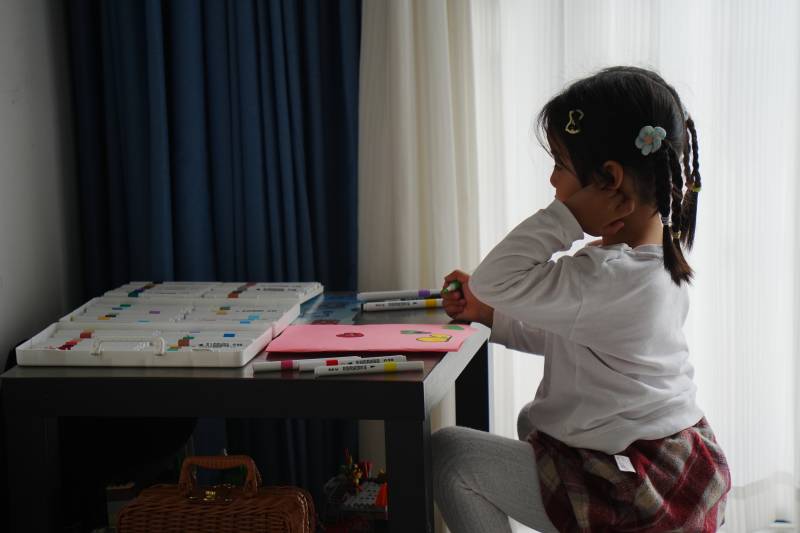 小女孩专注涂色图片