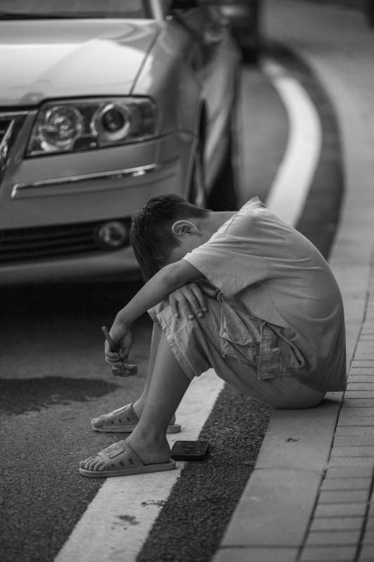 街头沉思的男孩图片