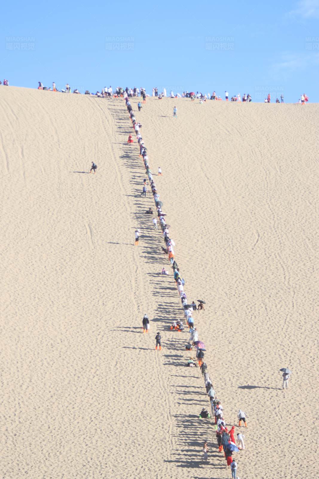 攀登沙丘的人群图片