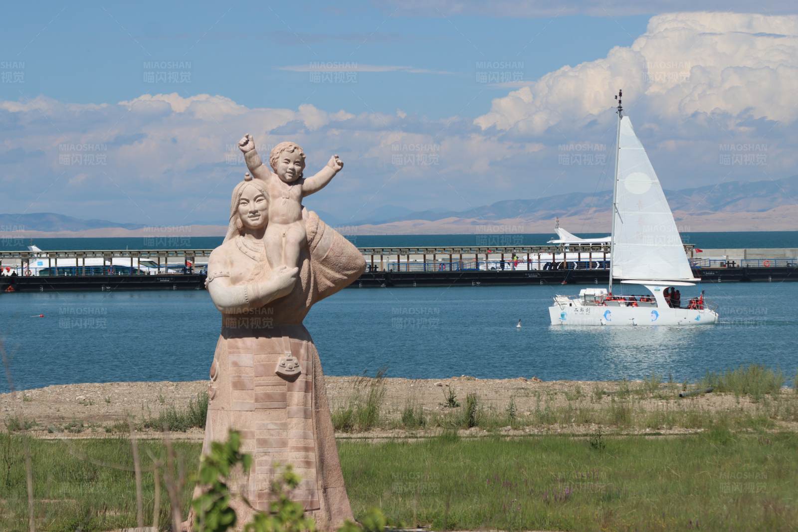 青海湖湖畔母子雕像与帆船图片